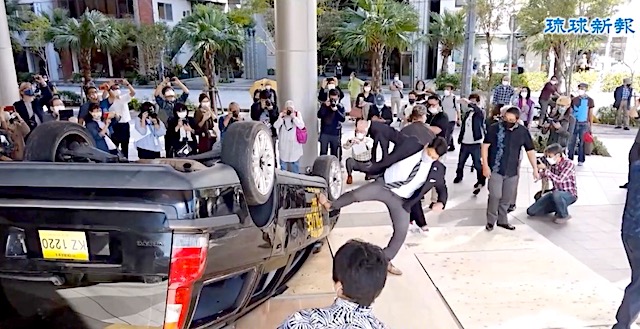 【沖縄】琉球新報社1階広場で軍警察のパトカーに見立てた車をひっくり返して蹴りつけ、破壊するイベントが開催される…